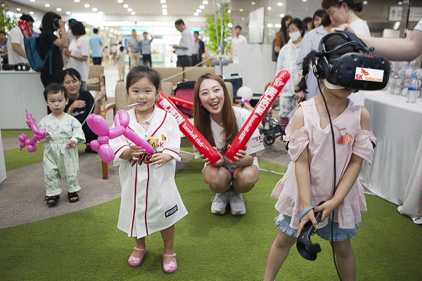 SK텔레콤이 지난 16일 인천시 중구 인하대병원 로비에 마련한 '찾아가는 야구장'에서 어린이 환자들이 가상현실기기를 통해 SK와이번스 프로야구를 실시간 시청하고 있다. (사진=SK텔레콤)