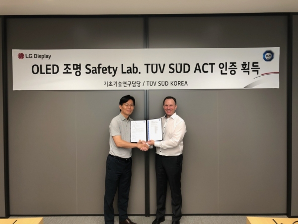 LG사이언스파크에서 배종욱 LG디스플레이 기초 기술 연구 담당(왼쪽)이 예쎄폴커 TUV SUD Korea 제품인증사업부 총괄전무로부터 인증서를 받고 있는 모습.(사진=LG디스플레이)
