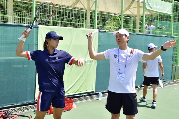 김세현 H농협은행 스포츠단 테니스 선수(왼쪽)가 고객에게 원포인트 강습을 하고 있다. (NH농협은행)
