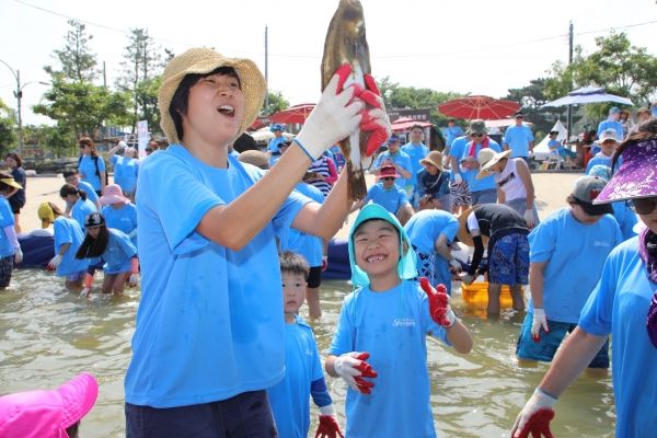 ‘Sh수협은행 제17회 사랑海 썸머페스티벌’에 참가한 고객 가족이 ‘맨손 물고기잡기’ 를 체험하고 있다. (사진=Sh수협은행)