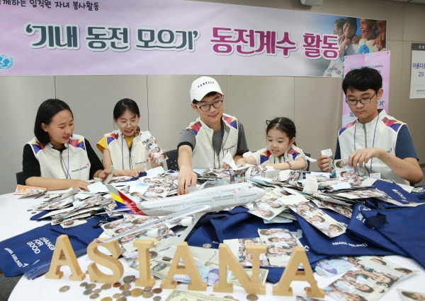 아시아나항공은 서울 강서구에 위치한 자사 교육훈련동에서 임직원과 자녀들이 고객들의 기부를 통해 모여진 동전들을 분류하는 '동전 계수 봉사활동'을 펼쳤다고 8일 밝혔다. 임직원과 자녀들이 동전 계수 봉사활동에 참여하고 있다. (사진=아시아나항공)