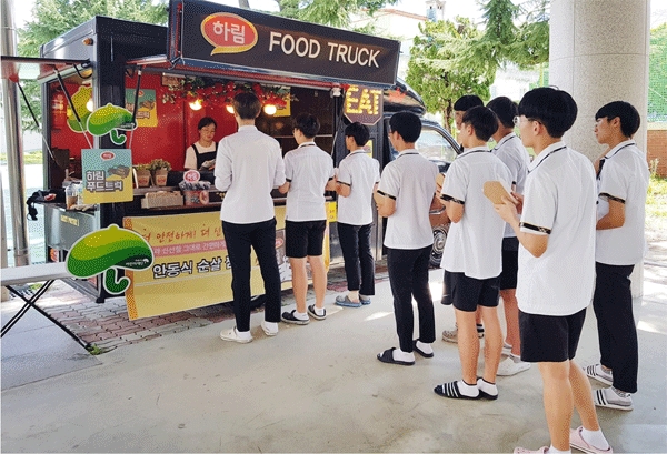 28일 광주 동구 중앙로 광주고등학교에서 학생들이 하림 푸드트럭을 찾아 안동식 순살찜닭을 건네받고 있다. (사진=하림)