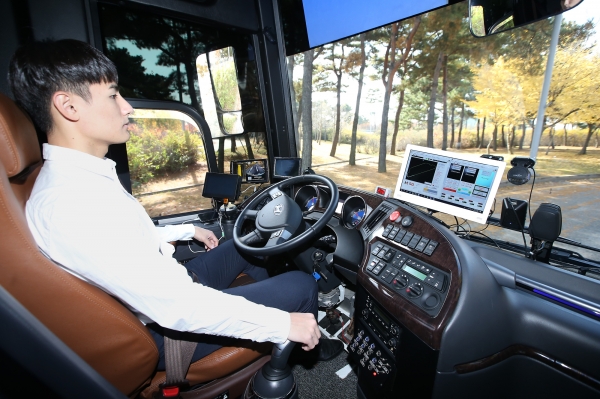 KT 자율주행 버스를 탑승한 KT 직원이 양손을 놓고 차량으로 전달되는 신호를 확인하고 있다. (사진=KT)