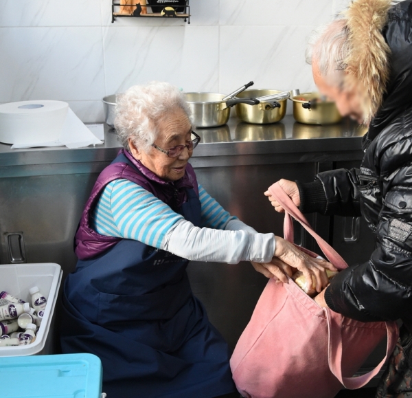 정희일 할머니가 무료급식소 토마스의 집에서 간식을 나눠주고 있다.(사진=LG)