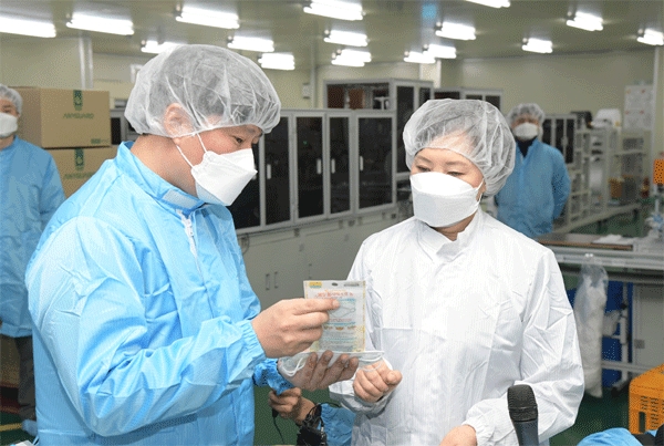 이의경 식품의약품안전처장(오른쪽)이 29일 경기 안성시 이앤더블유에서 생산하는 보건용 마스크를 살펴보고 있다. (사진=식품의약품안전처)