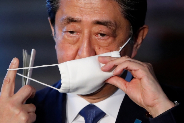 코로나19 긴급 기자회견에서 마스크 벗는 아베 신조 일본 총리. (사진=연합뉴스)