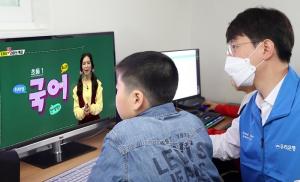 우리금융그룹의 자원봉사단원이 그룹홈 아동과 함께 공부방에서 온라인 수업을 듣고 있다. (사진=우리금융지주)