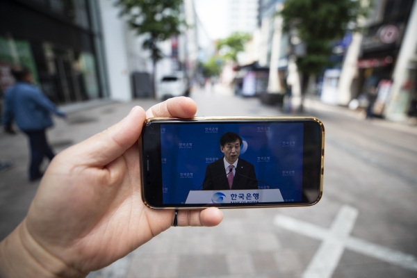 28일 오전 비교적 한산한 서울 명동 거리에서 취재진이 스마트폰을 들고 유튜브로 중계되는 '통화정책방향 이주열 한국은행 총재 기자간담회'를 선보이고 있다. (사진=연합뉴스)