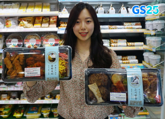 모델이 GS25에서 '피곤한날 먹는 고기반찬'(오른쪽)과 '판돌리고싶은 중화요리'를 들고 있다. (사진=GS리테일)