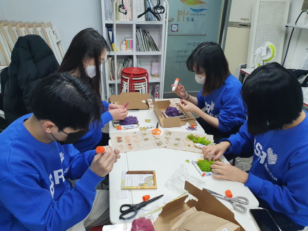 bhc 해바라기 봉사단 5기 2조 대학생들이 지난 19일 서울 은평구 불광동 '공간 나래'에서 스칸디아모스 액자를 만들고 있다. (사진=bhc)