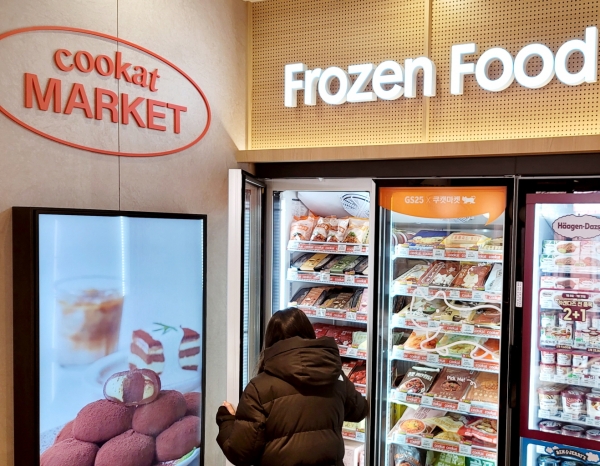 한 고객이 GS25합정프리미엄점에 시범 도입된 쿠캣 냉동매대에서 상품을 고르고 있다. (사진=GS리테일)
