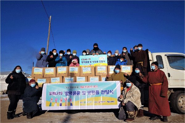 지난 23일 몽골 에르덴 솜 '카스 희망의 숲' 인근 하늘마을 주민들이 푸른아시아의 현지 활동가로부터 '따숨박스'를 건네받고 있다. (사진=오비맥주) 