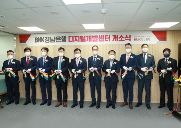 최홍영 BNK경남은행장(왼쪽에서 다섯 번째)과 IT사업을 진행 중인 협력사 대표들이 '디지털개발센터' 개소 축하 테이프를 자르고 있다. (사진= BNK경남은행)