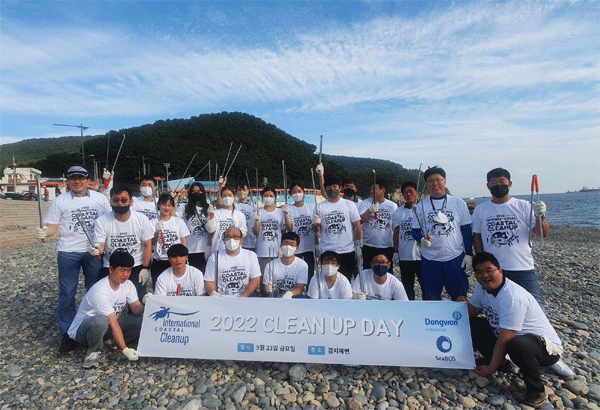지난 23일 부산 영도구 감지해변에서 '국제 해안 클린업데이'에 참여한 동원산업 임직원들이 단체사진 찍고 있다. (사진=동원산업) 