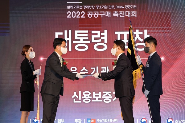 김충배 신용보증기금 전무이사(오른쪽)가 '2022 공공구매촉진대회'에서 조주현 중기부 차관으로부터 공공구매 유공 대통령 표창을 수여받고 있다. (사진=신보)