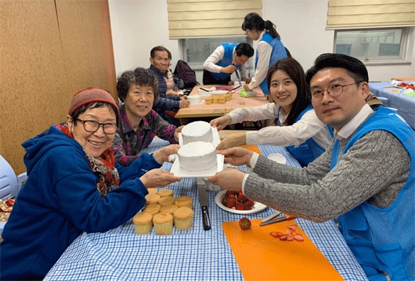 서울 서초구 우면종합사회복지관에서 21일 케이크 만들기 봉사활동을 펼친 JW그룹 임직원들이 어르신들과 기념사진을 찍고 있다. (사진=JW그룹) 