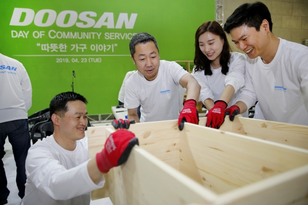 박정원 두산그룹 회장(오른쪽 세 번째)이 임직원들과 함께 인근 지역 가정에 전달할 가구를 제작하고 있다.(사진=두산그룹)