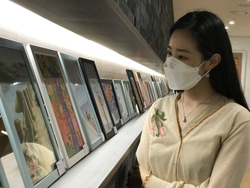 LG헬로비전의 직원이 상암동 사옥에 전시된 '자녀그림 콘테스트' 작품을 관람하고 있다. (사진=LG헬로비전)