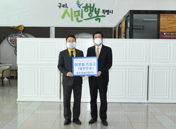 이병호 요진건설산업 상무(오른쪽)가 안승남 구리시장에게 이웃 돕기 성금을전달하고 있다. (사진=요진건설산업)