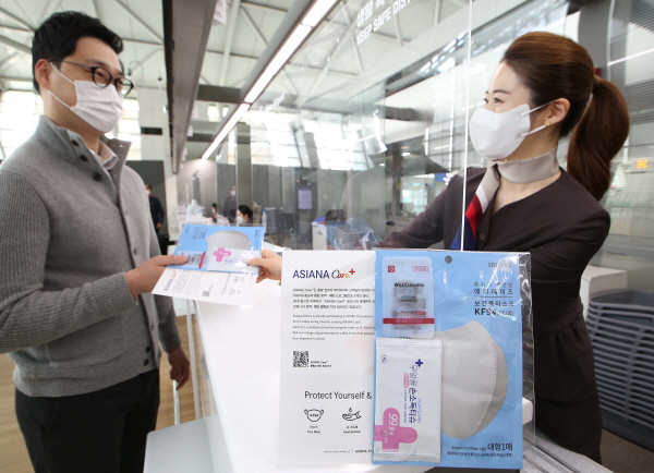 아시아나항공 직원이 통합 방역 프로그램에 따라 고객에게 키트를 제공하고 있다. (사진=아시아나항공)