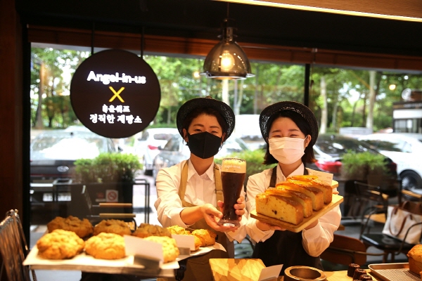 서울 송파구 잠실동 '엔제리너스X윤쉐프 정직한제빵소'에서 직원들이 빵과 음료를 보여주고 있다. (사진=롯데GRS)