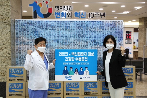 경기 고양시 명지병원에서 이진숙 동아오츠카 상무이사(오른쪽)가 김진구 명지병원장에게 포카리스웨트를 건네고 있다. (사진=동아오츠카)