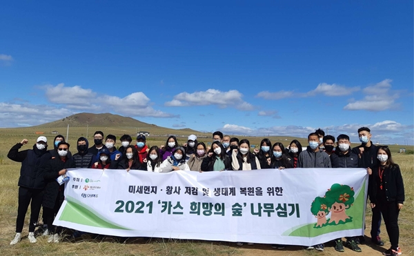 몽골 에르덴솜 일대에서 몽골 대학생과 현지 주민으로 구성된 환경봉사단이 '카스 희망의 숲' 나무 심기 봉사활동 전 기념사진을 찍고 있다. (사진=오비맥주)
