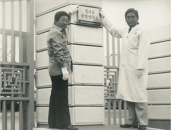 O falecido Lee Jong-ho (à esquerda), presidente honorário do JW Group, pendura uma faixa com o falecido Lee Han-pyo, diretor sênior de pesquisa, na cerimônia de fundação do Choongwae Pharmaceutical Research Center, realizada em 9 de setembro de 1983. ( Foto = JW Holdings) 